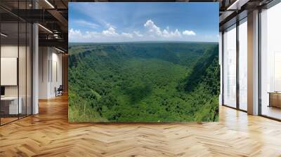 A breathtaking panoramic view of a large, green volcano with a fluffy white cloud hovering above its peak. Lush forests surround the volcano, and the sky is a bright blue with white fluffy clouds Wall mural