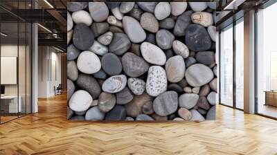 A close-up image of various smooth river rocks in shades of gray, brown, and white SEAMLESS PATTERN Wall mural