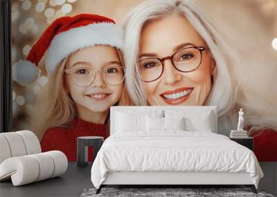 A joyful moment shared between a little girl and her grandmother, both smiling warmly in festive attire, capturing the essence of family and holiday spirit Wall mural