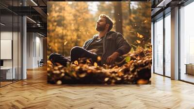 a man walking amidst a serene forest, with the ground blanketed in fallen leaves of vibrant autumn colors. The scene exudes the tranquility of a solitary autumn stroll. Wall mural