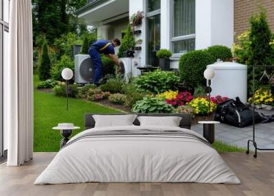 A technician in overalls works on water softener equipment amidst tanks in a grey Los Angeles home Wall mural