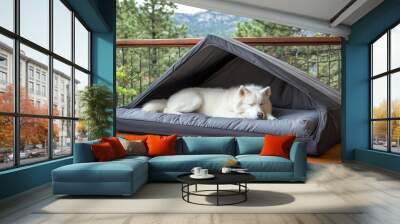 A white Samoyed enjoys a peaceful nap on a gray cushion in a cozy outdoor dog house, surrounded by greenery and sunlight, creating a serene atmosphere Wall mural