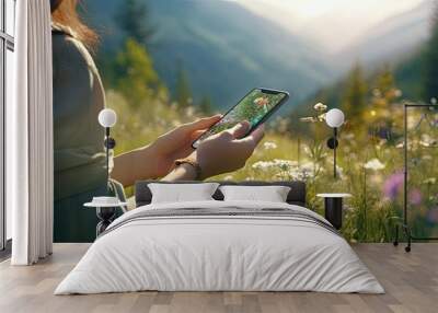 a woman's hands using a mobile phone against a scenic natural background, highlighting the convenience of staying connected while enjoying nature. Wall mural