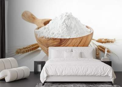 A wooden bowl filled with wheat flour, accompanied by a wooden spoon and a single ear of wheat, all isolated against a white backdrop. Wall mural