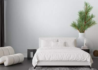 an empty white wall as a mock-up canvas, a stylish vase with green fir branches on a white table beneath the wall. This is a great way to showcase the simplicity of holiday home decor. Wall mural