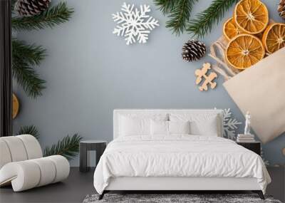 Eco-friendly bags filled with tangerine slices and surrounded by pine cones and conifer branches create a festive New Year atmosphere on a concrete table Wall mural