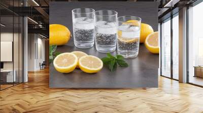 Experience a refreshing blend of ginger and lemon water with mint leaves served in clear glasses against a dark backdrop, ideal for a healthy lifestyle Wall mural