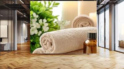 Soft light fills a serene bathroom featuring folded towels, bamboo accents, a scented candle, a green plant, and body lotion for a relaxing spa atmosphere Wall mural