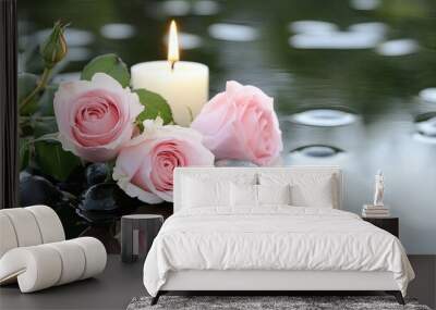 Soft pink roses and smooth black pebbles surround a lit candle, forming a peaceful spa setting that reflects tranquility in calm water for a romantic ambiance Wall mural