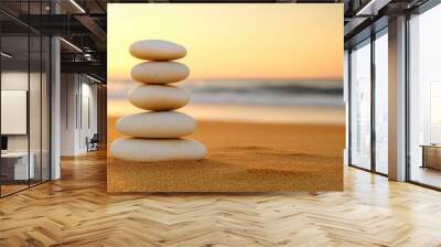 Stacked Zen stones create a peaceful focal point on a beach at sunset, surrounded by a tranquil sea and softened by warm evening light Wall mural