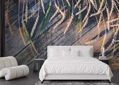 Harvest. Wheat and rye on wooden old background at sunset. Wall mural