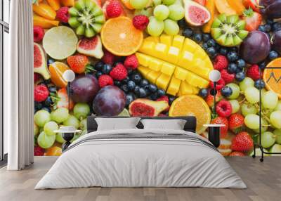 Assortment of healthy raw fruits and berries platter background, strawberries raspberries oranges plums apples kiwis grapes blueberries, mango, top view, selective focus Wall mural