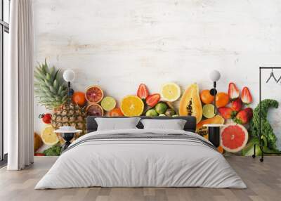 Fruits and vegetables rich in vitamin C, oranges mango grapefruit kiwi kale pepper pineapple lemon sprouts papaya broccoli, on wooden white table, top view, copy space, selective focus Wall mural