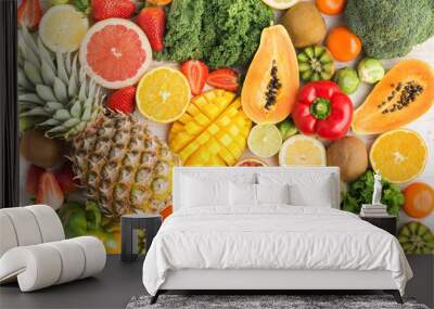 Fruits and vegetables rich in vitamin C background pattern, oranges mango grapefruit kiwi kale pepper pineapple lemon sprouts papaya broccoli, on white table, top view, selective focus Wall mural