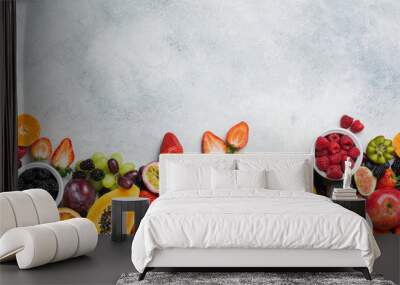 Healthy raw rainbow fruits background, mango papaya strawberries oranges passion fruits berries on oval serving plate on light kitchen top, top view, copy space, selective focus Wall mural