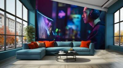 A confident Asian man, Gamer, streamer, Student wearing headphones, playing an online video game on a computer in a game room with neon pink blue lighting, Live streaming. Esports, Technology, concept Wall mural