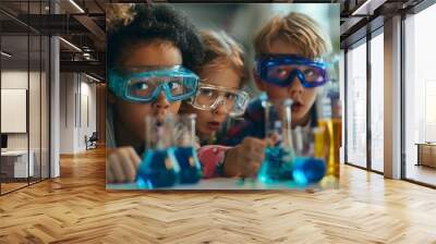 A group of children wearing blue safety goggles are looking at a table full of c Wall mural