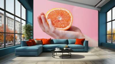 A hand holding a slice of orange Wall mural