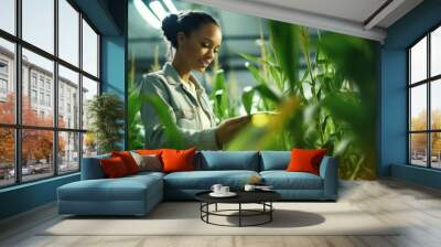 A happy female geneticist scientist checks the growth of plants, examines crops, pests, develops new varieties of corn in the greenhouse. Bioengineering, Biotechnology, Agronomy concepts. Wall mural