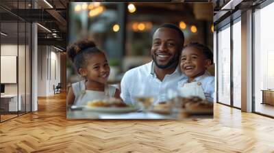 A man and two children are sitting at a table with food in front of them Wall mural