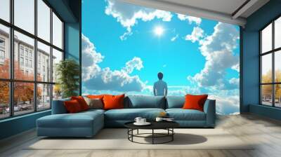 A man stands in front of a blue sky with clouds Wall mural