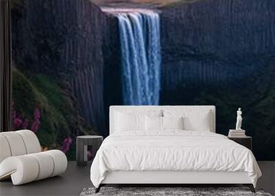 A waterfall with a beautiful view of the sky and flowers Wall mural