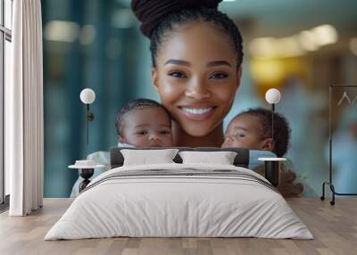 A woman is holding two babies in her arms, both of whom are wrapped in blankets Wall mural