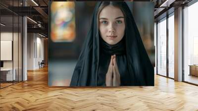 A woman wearing a black veil and praying Wall mural