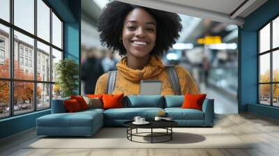 A woman with curly hair is smiling and holding a cell phone Wall mural