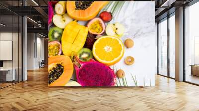 Exotic fruits and tropical leaves on table Wall mural