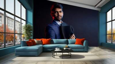 Indian young businessman on dark background Wall mural