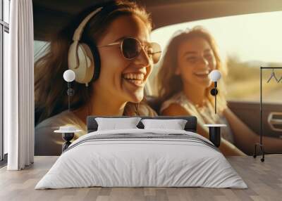 Two young women listen and sing songs, dance in the car during the trip. Best friends have fun together, Travel at sunset. Wall mural