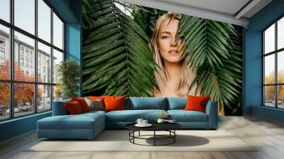 Woman in swimsuit on tropical plants background Wall mural