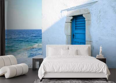 Traditional white building with blue door at the seaside. Mykonos island, Greece Wall mural