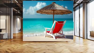 A beach chair under a thatched umbrella on a sandy beach with a blue ocean in the background. Wall mural