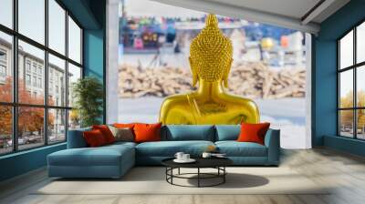 Golden buddha in front of log pile Wall mural