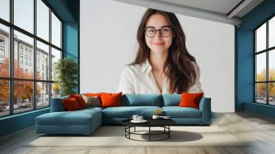 Brunette woman with glasses smiling and posing with crossed arms looking at the camera on a white background Wall mural