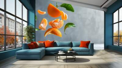 Healthy snack ripe tangerine or orange slices levitating on a white wooden table against a gray wall packed with vitamins Wall mural