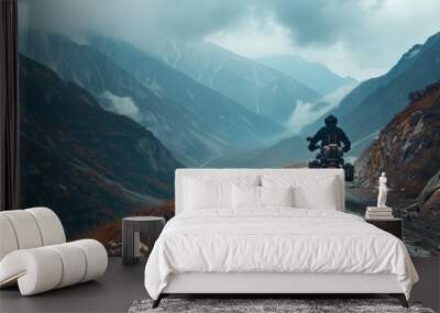 Motorcyclist braving cold overcast weather on mountainous dirt roads embodying extreme sport and active lifestyle in enduro off road touring Wall mural