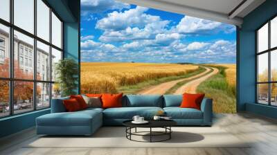 Scenic rural view with wheat field blue sky white clouds dirt road Wall mural