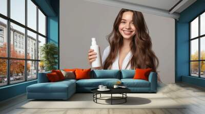 smiling woman with long healthy hair advertising organic shampoo on palm isolated on studio backgrou Wall mural