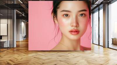 Studio portrait of a beautiful Asian woman with glowing skin taking care of her face at a spa Wall mural