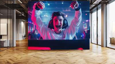 Successful eSports gamer joyfully celebrates victory in online cyber championship tournament with a front view portrait shot Wall mural