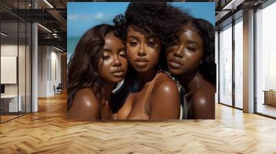 Three sensual young black females with attractive makeup and beautiful hairstyles posing alone at the beach in brown bathing suits Wall mural