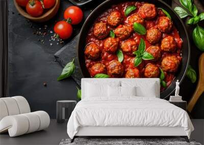 Top view of meatballs and tomato sauce in a frying pan on a dark stone table Wall mural