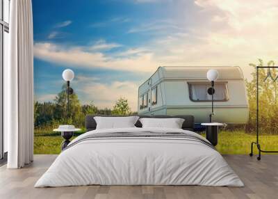 White caravan trailer on a green campground sunny spring day in Europe Lifestyle travel ecotourism road trip vacations recreation with RV Wall mural