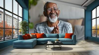 A happy senior man in living room clapping with joy and inspiration Wall mural