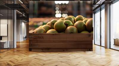 Kiwi fruits harvested in wooden boxes in a warehouse. Natural organic fruit abundance. Healthy and natural food storing and shipping concept. Wall mural