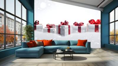 Large horizontal row of Christmas gifts with red ribbons and spruce trees on snow covered surface, snowfall and abstract background with snowflakes and sparkling lights. Wall mural