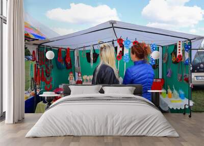 Girls choose jewelry at a crafts fair in Ukraine Wall mural